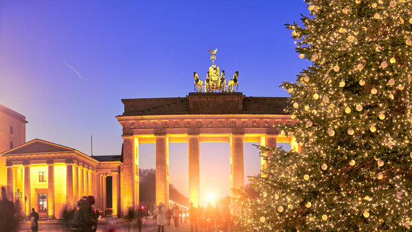Panoramic image of Brandenburger Gate in Berlin with Christmas tree on a sunset with evening illumination. 