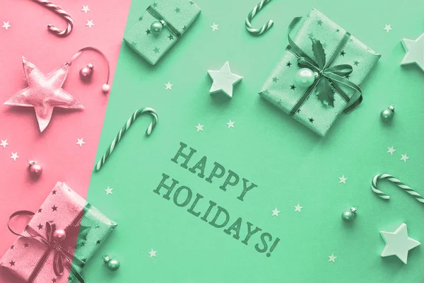 节日快乐 单色以粉红色和绿色的新薄荷色分割了两种色调的圣诞背景 圣诞礼品盒 条状糖果手杖 小饰物和几何图形的星星 — 图库照片