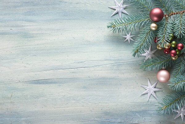 Christmas background: corner decorated with fir twigs, berries and Christmas baubles on light neutral background, text space