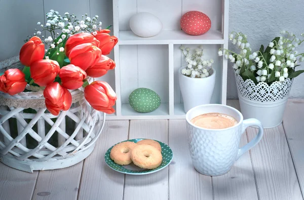 赤いチューリップと春の装飾が施された白い木製のテーブルの上のコーヒーとクッキーのカップ — ストック写真