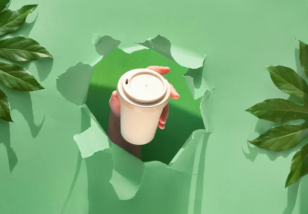 Hand Houden Van Een Kopje Koffie Door Een Gat Gescheurd — Stockfoto