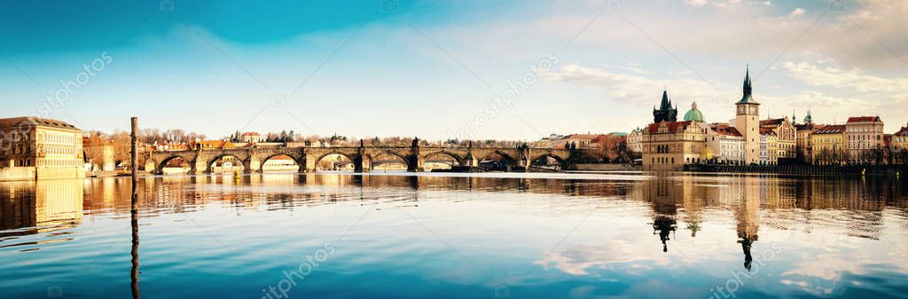 Prague, Charles bridge reflected in Vltava river in the morning, panorama image for your banner or webpage design. This image is toned.