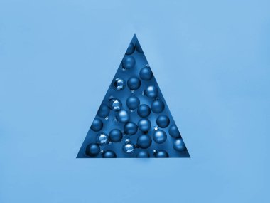 Geometrik yaratıcı Noel dairesi. Tek renkli imge mavi renkte. Noel ağacı şeklinde üçgen kağıt delikte Xmas mücevherleri..