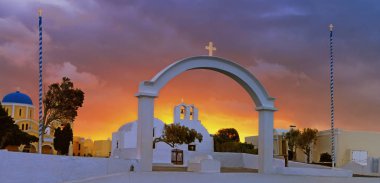 Yunanistan 'ın Santorini adasındaki Oia köyündeki kemer, kilise ve çan kuleleri dramatik gökyüzü ile gün doğumunda
