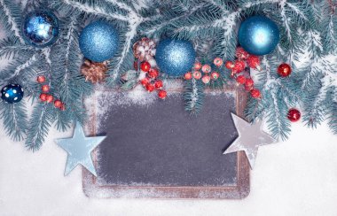 Karda Noel süsleri olan boş bir karatahta. Üst görünüm, metin alanı