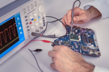Ana kartı kontrol eden test cihazına yakın çekim teknolojisi. Tonlanmış görüntü. Sığ Dof, eline ve test uçlarına odaklan. Bu resim tonlandırılmış.