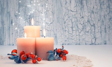 Tarafsız arka planda Noel süslemeleri olan üç yanan mum. Üçüncü Advent. Bu resim ayarlı, metnin için boşluk