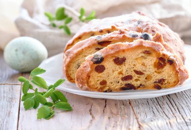 Paskalya Ekmeği (Almanca Osterbrot). Taze yaprakları ve bıldırcın yumurtası ile rustik ahşap üzerinde geleneksel fruty ekmek yakın çekim. Paskalya kutlamaları için geleneksel Alman tatlısı.