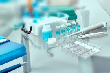 Histopatolojiyle ilgili sunum için bulanık bir arkaplan. Cam üzerinde lekeli doku örnekleri, sabitlenmiş doku, otomatik pipet ve işle ilgili diğer aletler. Tonu ayarlanmış resim, metin alanı. 