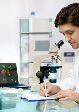 Genç ve enerjik erkek teknolojisi veya bilim adamı araştırma tesisinde çalışıyor.