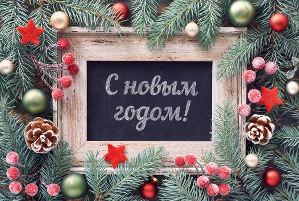 Happy New Year text in Russian language. Christmas frame in green and red, top view. Fir twig decorated with baubles, berries, pine cones and stars — ストック写真