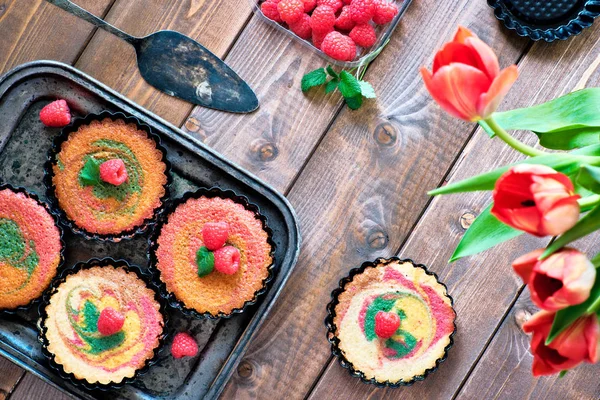Flat lay with small parrotot cakes decorated with raspberry and — Stock Photo, Image