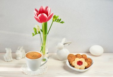 Cam vazoda bahar çiçekleri, Paskalya tavşanları, espresso ve Cooki.