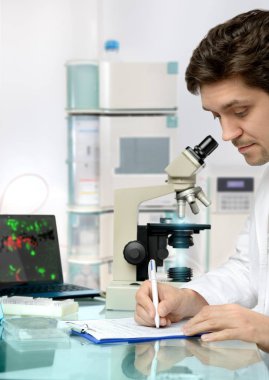 Genç ve enerjik erkek teknolojisi veya bilim adamı araştırma tesisinde çalışıyor.