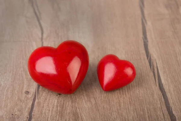 Deux cœurs de pierre rouge sur la surface en bois — Photo