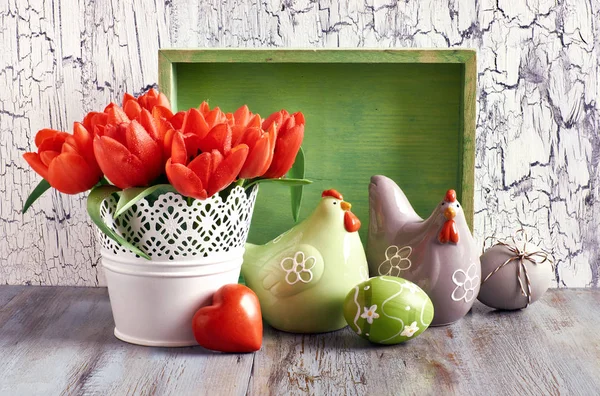 Пасхальная композиция с красными тюльпанами, керамическими курами и пасхальными яйцами — стоковое фото