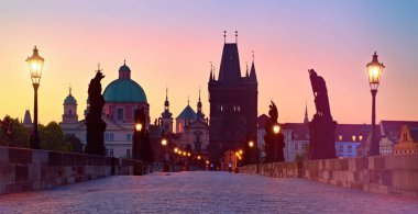Charles Bridge, Briç Kulesi 'nin silueti ve Çek Cumhuriyeti Prag' da sokak lambalı Aziz heykelleri.