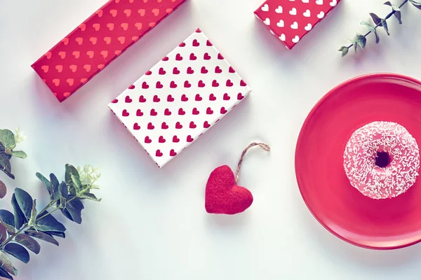 San Valentín plano yacía en cian blanco y rosa, vista superior con diseño de corazón. Fondo geométrico con eucalipto. Cajas de regalo, rosquilla rosa en plato y corazón textil . — Foto de Stock