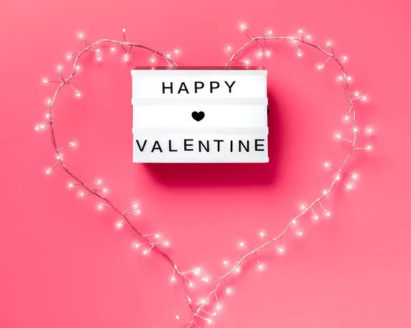 Valentine flat lay, vista superior sobre fundo rosa. Lightbox com texto "Happy Valentine". guirlanda leve em forma de coração em torno da caixa. Conceito de dia de São Valentim minimalista na moda . — Fotografia de Stock