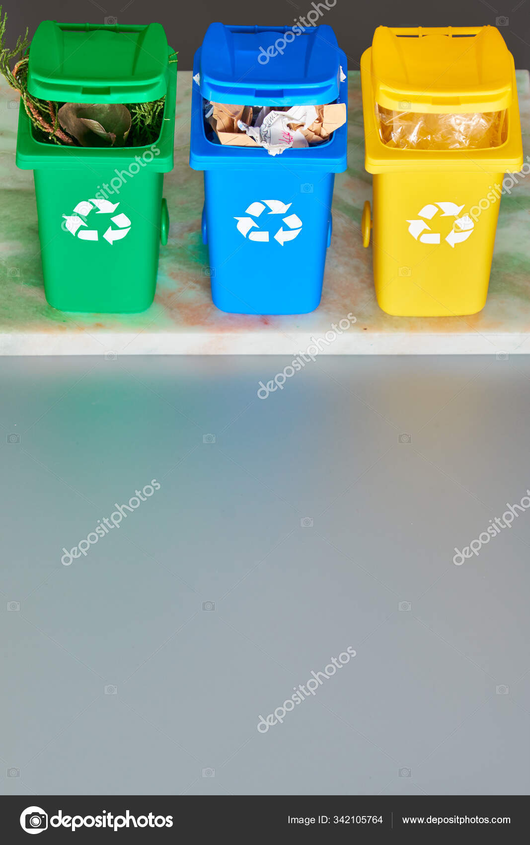 Tres contenedores de reciclaje codificados por colores, proyección