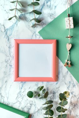 Beautiful abstract floral background. Flat lay, top view eucalyptus on marble background, light textured stone surface. Trendy geometric background with copy-space in pink frame.
