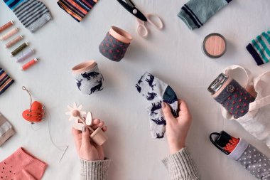Zero waste household. Making bamboo cup and thermos can sleeves from stray socks. Upscale of orphaned mismatch socks. Flat lay, textile background. Eco friendly low impact lifestyle concept.