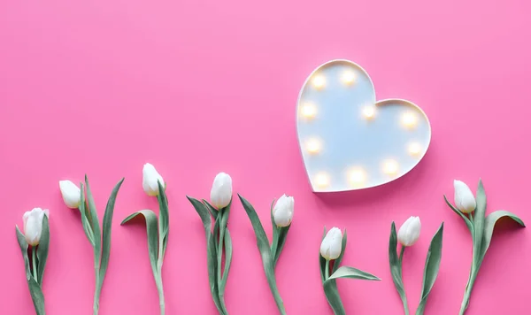 St Valentine's day pink background. Wave parallel geometric line of white tulip flowers. Lightboard in heart shape with illuminated lights. Flat lay, top view, trendy Valentine design background. — ストック写真