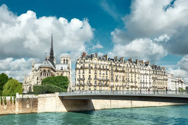 Paris, panorama sobre o rio Sena com a catedral de Notre-Dame de trás em um dia brilhante na primavera com nuvens dramáticas lindas e céu azul.Este fundo de viagem na França imagem panorâmica é tonificada . — Fotografia de Stock