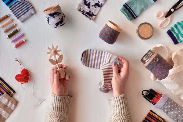 Zero waste household. Making bamboo cup and thermos can sleeves from stray socks. Upscale of orphaned single socks. Flat lay, textile tablecloth. Eco friendly low impact sustainable lifestyle concept.