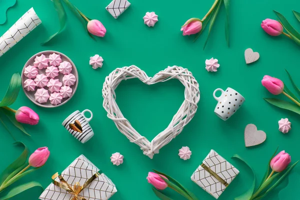 バレンタインの日付を持つ幾何学的なバレンタインフラットは、カレンダー、花、贈り物、心、ピンクのマシュマロとコーヒーカップに2月14日。緑の背景に白と金のバレンタインデーの配置 — ストック写真