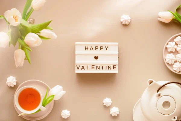 Valentine toned composite background, collage. Geometric panoramic flat lay with hands. Cup of black tea, tea pot, sweets and white tulips on grey with lightboard. Text Happy Valentine day. — Stockfoto