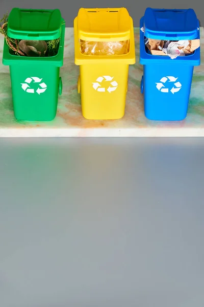 Trois bacs de recyclage à code couleur, image isométrique sur fond gris avec espace de copie. Panneau de recyclage, poubelles, bleu, jaune et vert. Séparation des déchets pour réduire la pression antropogénique . — Photo