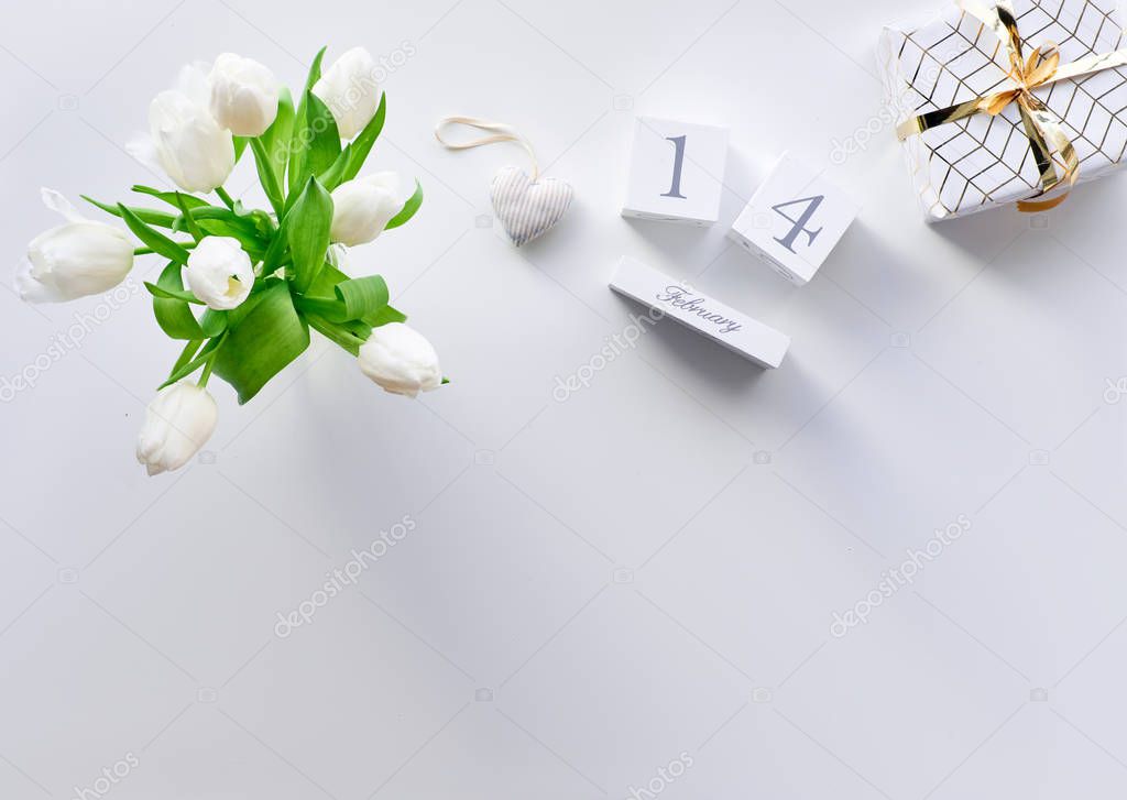 Valentines day geometric panoramic flat lay, top view on white background. Tulips, coffee cups and marshmallows, text space. Valentine gift wrapped in paper. Wood calendar with 14 February.
