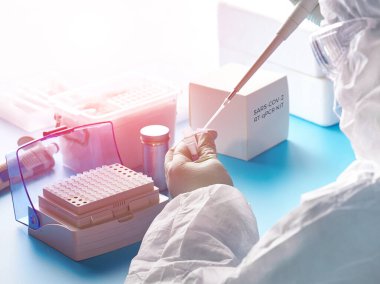Sars-Cov-2 PCR tanı kiti. Koruyucu giysi, maske ve gözlük giyen epidemiyoloji uzmanı, 2019-ncov virüsünün belli bir bölgesini tespit etmek için hasta örnekleriyle çalışır..