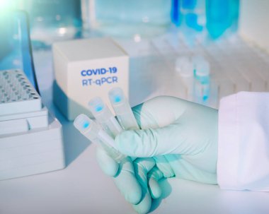 Hasta örneklerindeki yeni Covid-19 koronavirüsünü tespit etmek için test kiti. Rt-Pcr kit reaktifleri viral Covid19 Rna 'yı DNA' ya dönüştürür ve 2019-ncov 'un belirli bir bölgesini güçlendirir. Eldivende test tüpleri var..