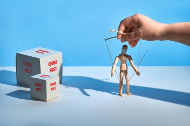 Çin 'den gelen posta paketleri, zarflar ve paketler. Çinli teslimatçılar COVID-19 virüsünü kapmak için sahte haber ve korkudan muzdaripler. Yüz maskesi takmış el ele tutuşan kukla.