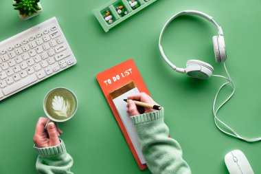Merkez ofis, yaratıcı konsepti listelemek için. Yaşlı kadın elleri bir gün planlıyor. Koronavirüs krizi sırasında zaman yönetimi. Nane yeşili arka planda yaratıcı bir daire. Salgınlardan kurtulma planım..