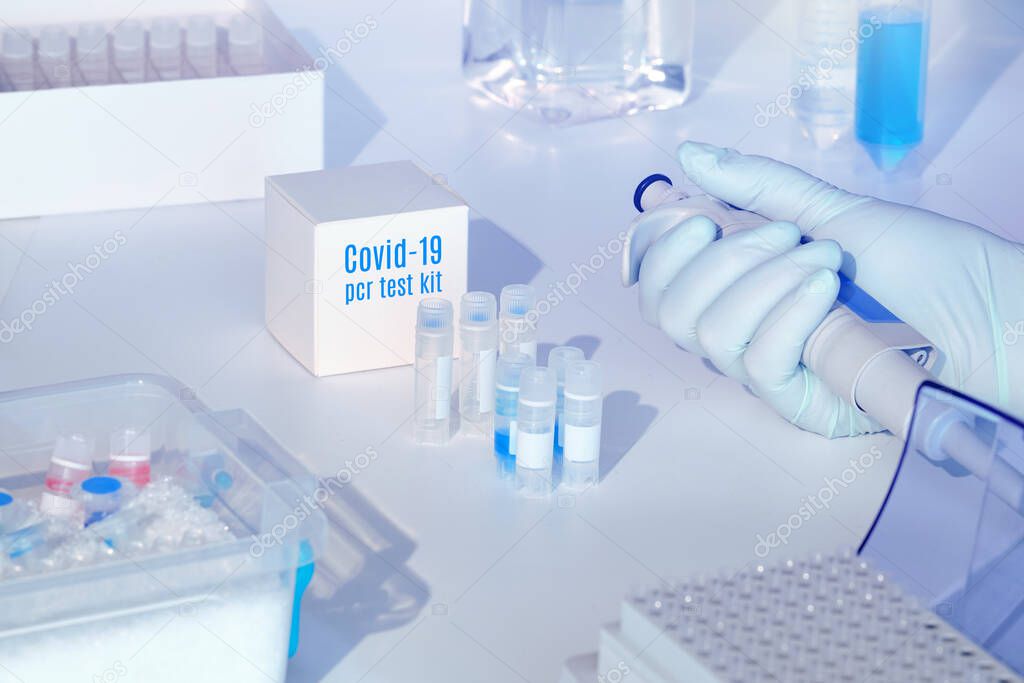 Quick novel coronavirus test kit. 2019 nCoV diagnostics kit. Hand in glove with automatic pipette. RT-PCR kit to detect covid19 virus in clinical samples. est based on real-time PCR technology.