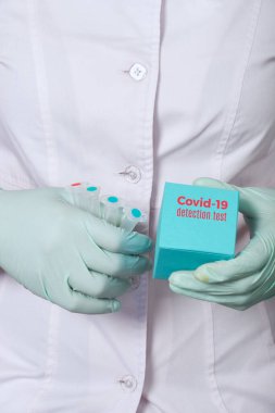 Nükleik asitlerin tespiti için test sistemi, Covid-19 teşhisi için hastalarda yeni koronavirüs SARS-CoV-2 için rna. Sıhhiye, beyaz önlük ve nane yeşili eldivenli teknoloji test sistemi reaktörleri taşıyor.