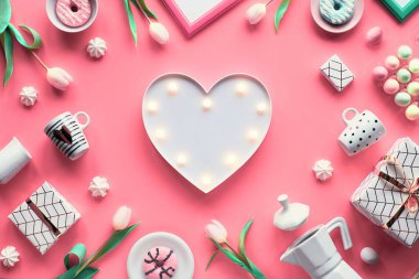 Geometrik yay dairesi pembe arka planda beyaz ve yeşil renkte yatıyordu. Paskalya, Anneler Günü, 8 Mart Uluslararası Kadınlar Günü. Işıklı kalp lambası, Paskalya yumurtası, kahve fincanı, beyaz lale, hediyeler.