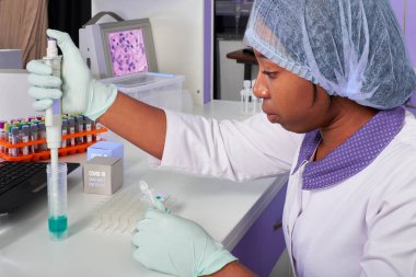 Afrikalı bilim adamı, teknik asistan veya laboratuvar önlüğü, koruyucu şapka ve eldiven giyen mezun modern test laboratuvarında SARS-CoV-2 virüsü için PCR testini optimize ediyor. Nükleik asit testlerinin sorun çıkarması.