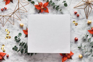 Taze okaliptüs dallarıyla Noel çerçevesi, kırmızı noktalı çiçekler, geometrik dekorasyonlar - altıgenler, metal tel şekiller. Beyaz mermer arka planda son moda üst görünüm. Beyaz tuval üzerinde kopyalama alanı.