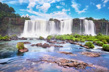 Arjantin 'de Iguazu şelaleleri. Birçok görkemli ve güçlü su çağlayanlarının panoramik görüntüsü ve bulutlu mavi gökyüzünün yansıması. Iguazu vadisinin panoramik görüntüsü.