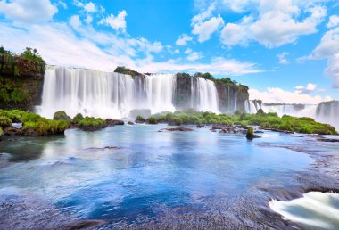 Arjantin 'de Iguazu şelaleleri, Şeytan Ağzı manzaralı. Birçok görkemli ve güçlü su çağlayanlarının panoramik görüntüsü ve bulutlu mavi gökyüzünün yansıması. Iguazu vadisinin panoramik görüntüsü.