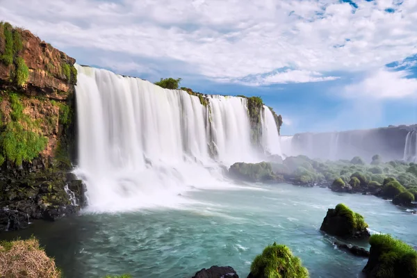 Arjantin 'de Iguazu şelaleleri, Şeytan Ağzı manzaralı. Sis ile çağlayan birçok görkemli ve güçlü suyun panoramik görüntüsü. Geniş ve güçlü şelalenin yan görüntüsü. Turkuaz su ve taşlar.