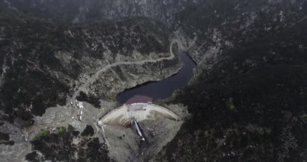 Drone Sparato Stagno Dietro Una Diga Montagne Boscose Scure Sotto — Video Stock