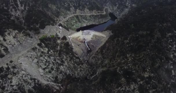 Flygfoto Damm Som Håller Tillbaka Damm Skogsklädda Berg Med Slingrande — Stockvideo