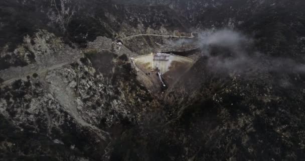 Tiro Aéreo Água Derramando Uma Barragem Perto Uma Estrada Sinuosa — Vídeo de Stock