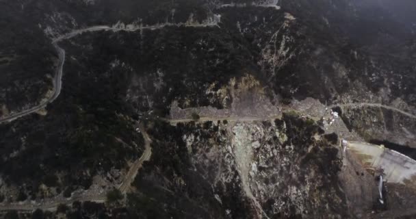 ドローンは2本の曲がりくねった道 ダムと森林に覆われた山々の貯水池 カリフォルニア州サンタアニタキャニオン アメリカ を撮影しました — ストック動画