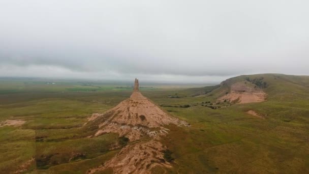 Dron Pomalu Pohybuje Vrcholu Kamenného Pilíře Zelenými Poli Kopcem Pozadí — Stock video